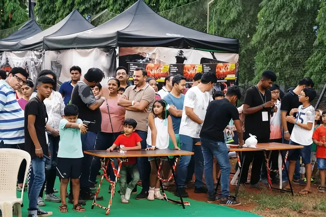 Groups of guests gathered around activity tables at an outdoor event