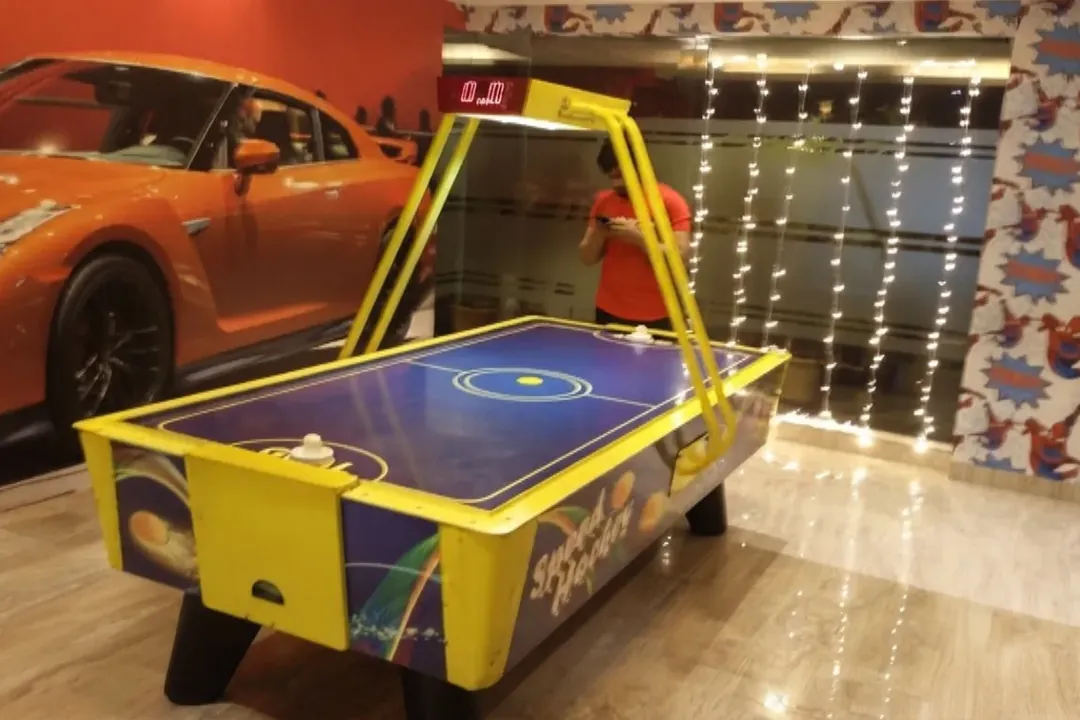 Air hockey table set up beside a sports car at an event