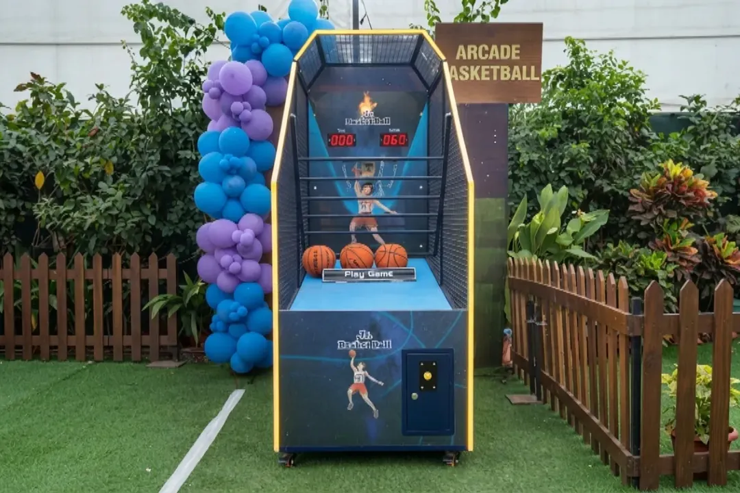 Arcade basketball machine set up in a garden with balloons