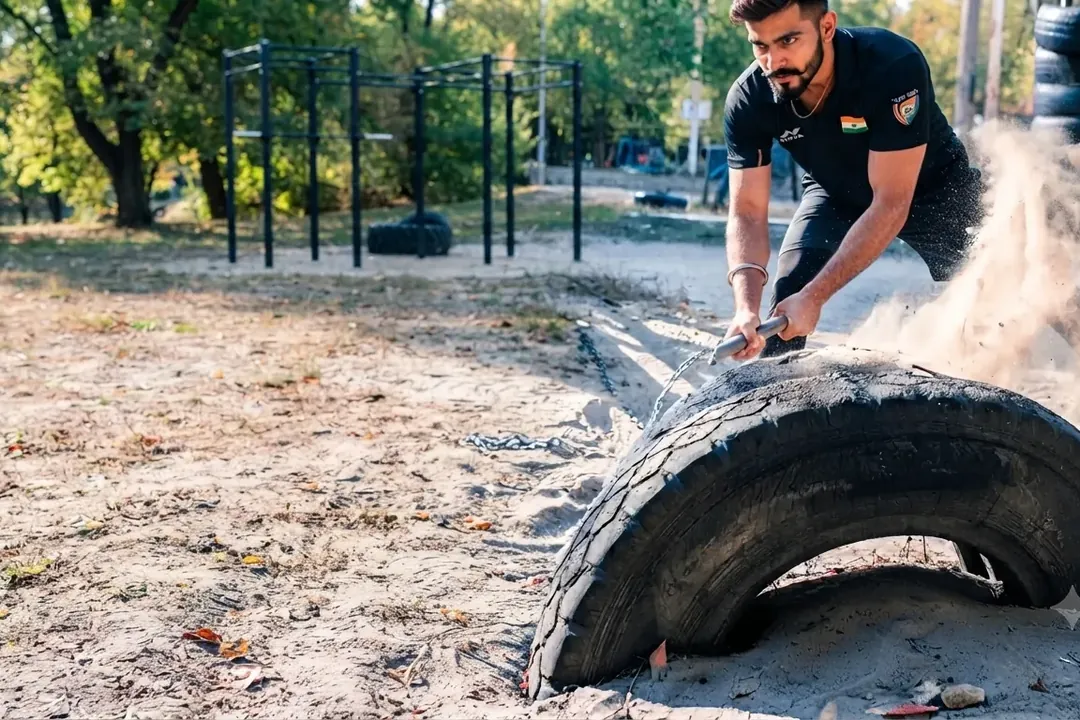 Man flipping a large tyre during a fitness challenge