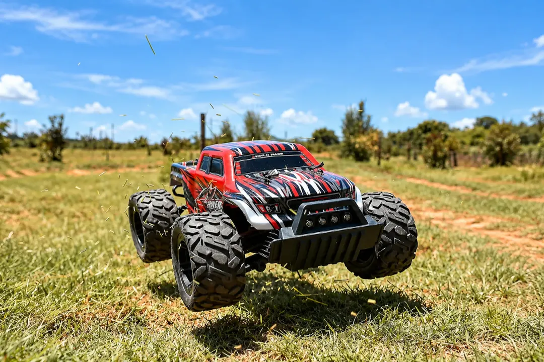 Red radio-controlled off-road car on grass