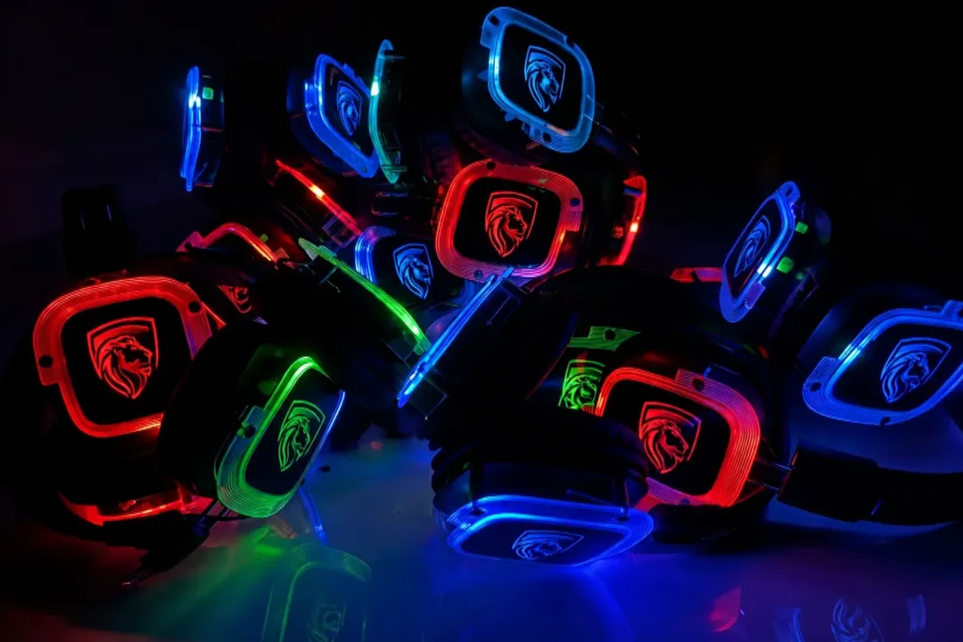 Pile of wireless silent disco headphones glowing red, blue and green