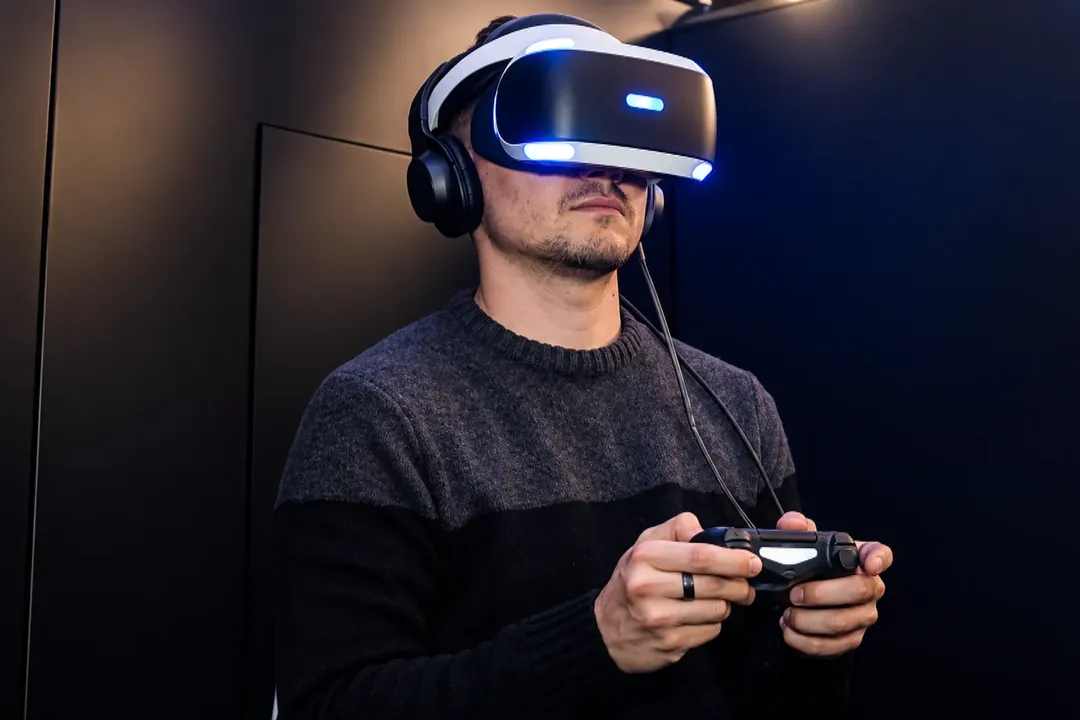 Man wearing a VR headset and holding a game controller